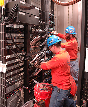 Men in hard hats working in a data center