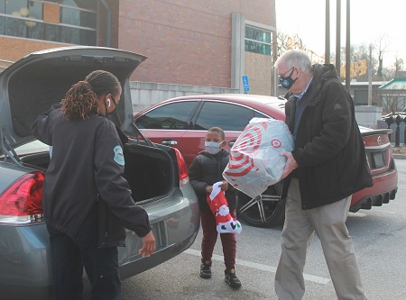 Man loading gifts into trunk of car
