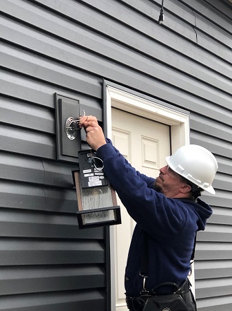 Electrician installing outdoor light fixture