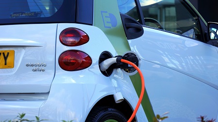 Electric vehicle hooked up to a charging station